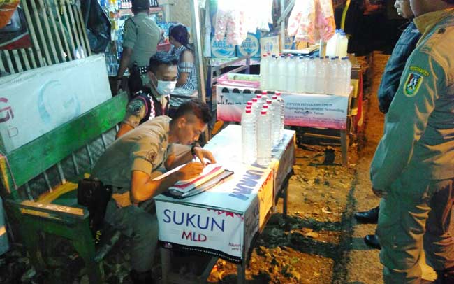 Petugas saat melakukan pendataan terhadap pada pemilik warung yang kedapatan menjual arak. foto: suwandi/ BANGSAONLINE