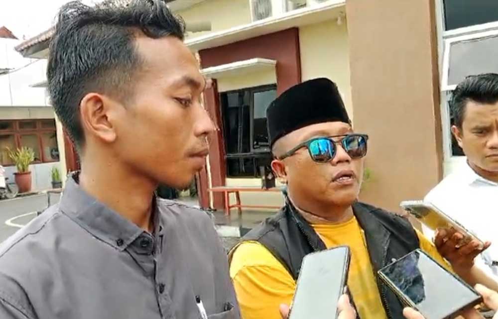 Fauzi didampingi Suhri, Pimred JTV Madura, memberikan keterangan usai melapor ke Polres Pamekasan.