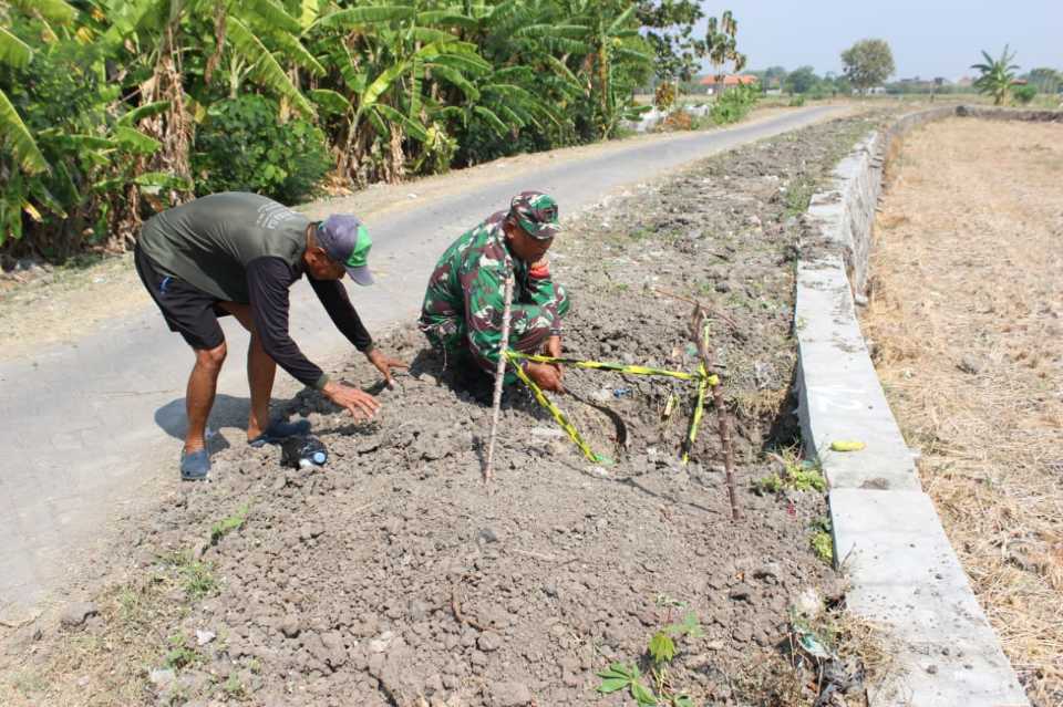 Satgas TMMD dan warga menyiapkan pemasangan PJU di Desa Kedondong Tulangan. foto ist
