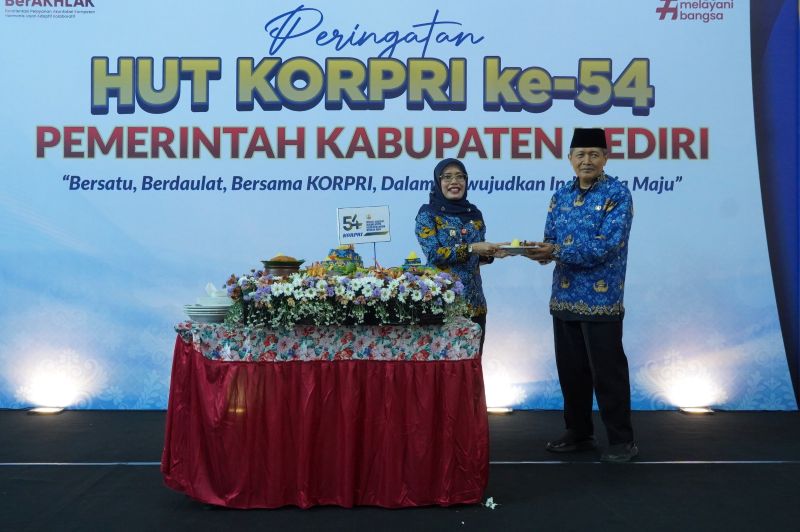 Wakil Bupati Kediri Dewi Mariya Ulfa saat menyerahkan potongan tumpeng kepada Dewan Pengurus KORPRI Kabupaten Kediri, Mohammad Solikin.
