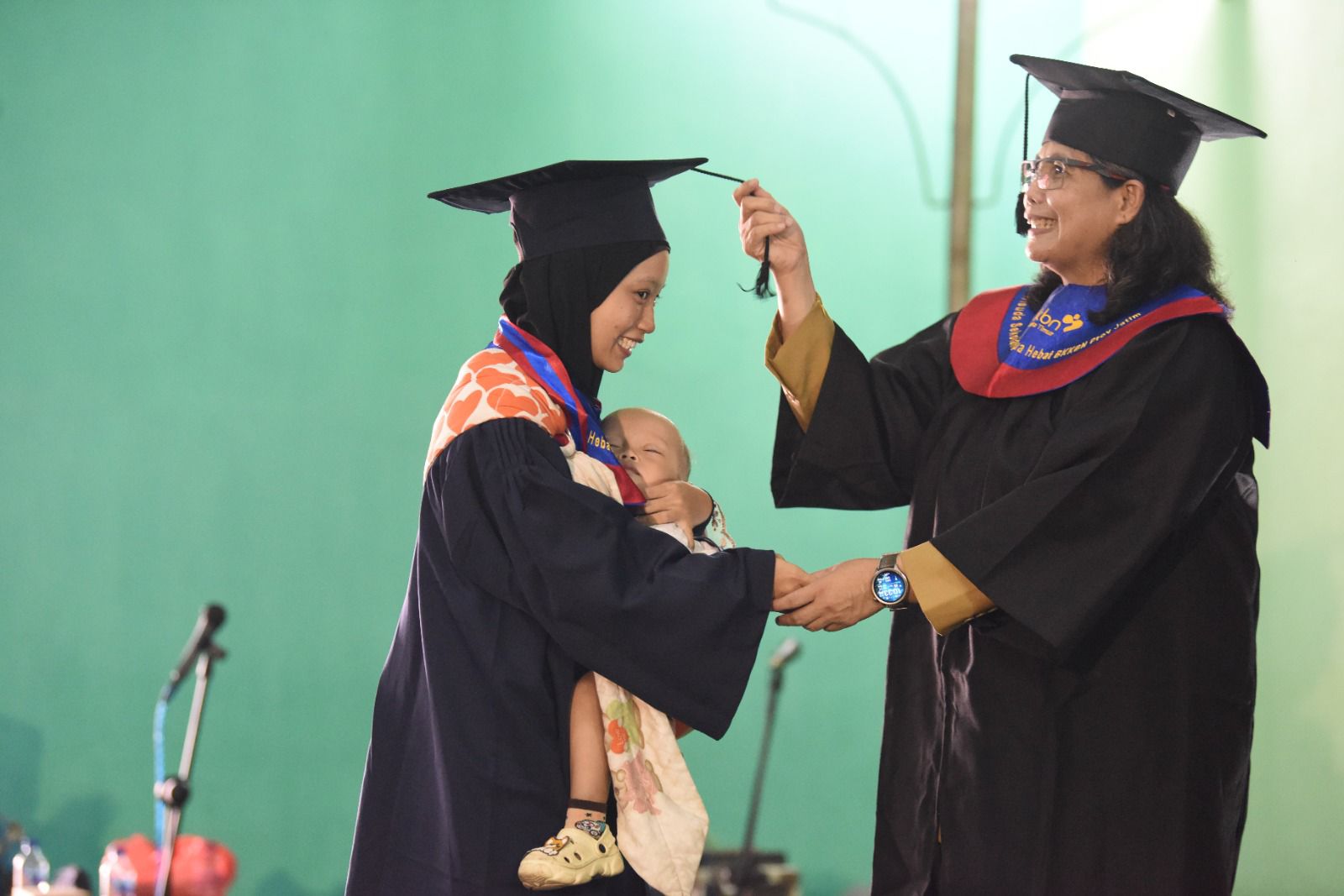 Pj. Wali Kota Kediri Zanariah saat mewisuda salah satu wisudawati. (Ist).