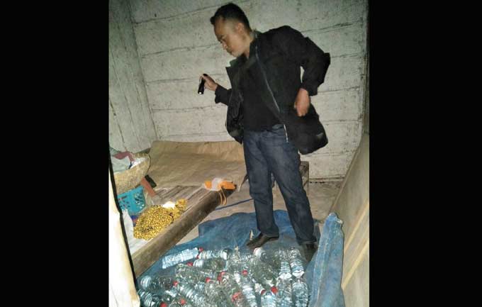 Petugas memperlihatkan barang bukti puluhan botol miras. foto: SUWANDI/ BANGSAONLINE