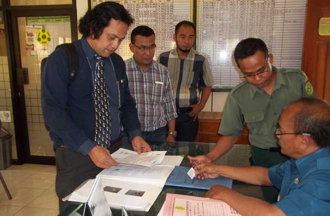 Guruh (kemeja kotak-kotak berkacamata) didampingi kuasa hukumnya saat mendaftar di PN pganjuk untuk mengajukan gugatan perdata kepada PT MBA. foto: BAMBANG DJ/ BANGSAONLINE