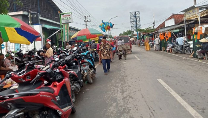 Kondisi kendaraan yang terparkir di bahu jalan Pasar Kedungdung, Sampang. Foto: MUTAMMIM/BANGSAONLINE