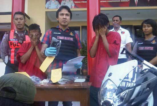 Polisi tunjukan ponsel hasil jambretan kedua tersangka. foto: rusmiyanto/BANGSAONLINE