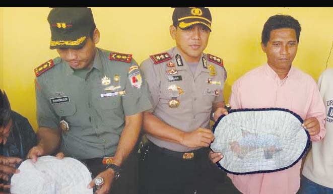 Barang bukti dua keset bertuliskan ayat Alquran diperlihatkan kepada wartawan.