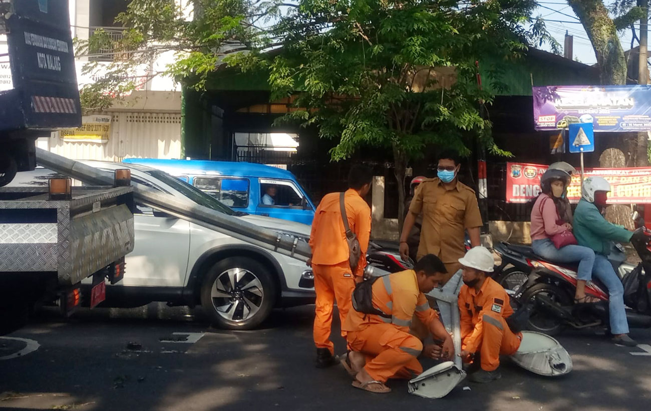 Petugas mengevakuasi tiang PJU yang roboh di Jalan Letjen Sutoyo, Kota Malang.