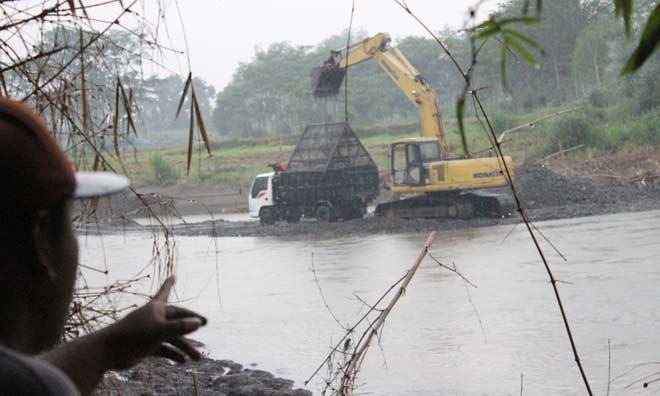 Warga menunjukkan penampang pasir yang menggunakan alat berat di desa Bukur, Kecamatan Sumbergempol, Tulungagung. foto: feri/ BANGSAONLINE