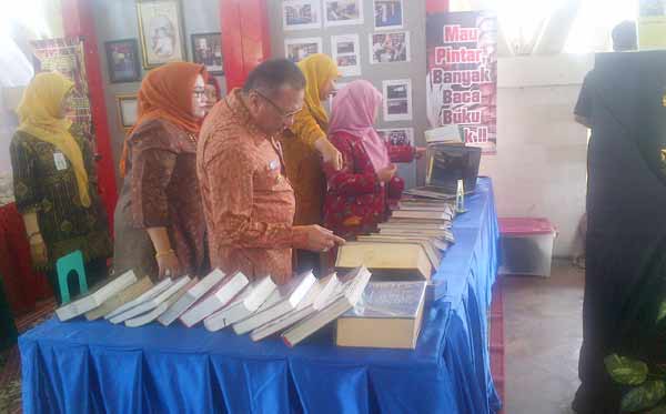 Penjabat (Pj) Bupati Gresik, Akmal Boedianto, saat menyerahkan penghargaan kepada  perwakilan SMPN 1 Balongpanggang. foto: syuhud/BANGSAONLINE
