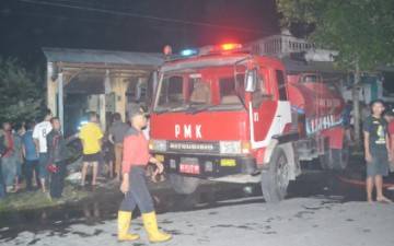 Petugas Pemadam Kebakaran saat memadamkan api di sebuah rumah di Desa Brenggolo Kecamatan Plosklaten. (foto: dendi martoni/BANGSAONLINE)
