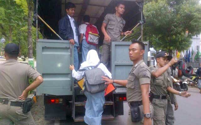 Para pelajar yang ketahuan nongkrong saat diangkut ke truk untuk dibawa ke kantor Satpol PP. foto: suwandi/ BANGSAONLINE