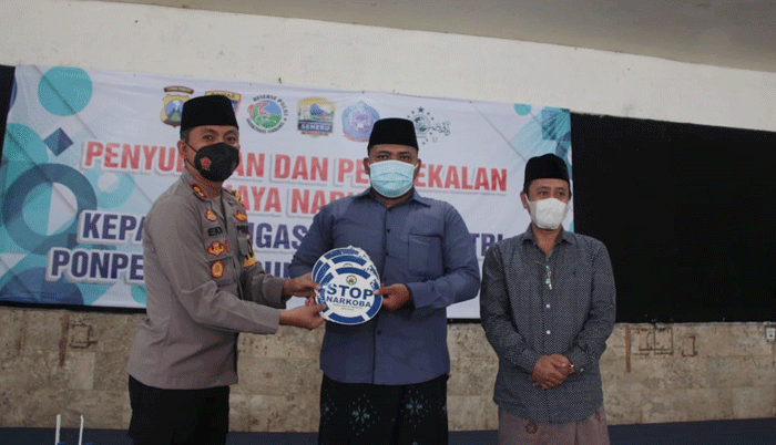 Kapolres Kediri Kota AKBP Eko Prasetyo saat menyerahkan sticker "Stop Narkoba" kepada salah satu pengasuh Pondok Pesantren Lirboyo disaksikan oleh Ketua PCNU Kota Kediri, KH. Abu Bakar Abdul Djalil/Gus Ab (kanan). foto: ist.