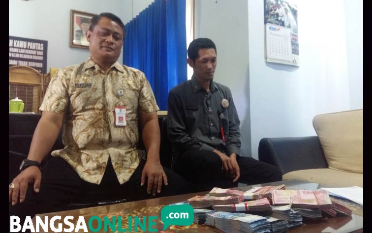 Kepala Inspektorat Lumajang saat menunjukkan hasil OTT senilai Rp 157 juta rupiah di satu Kecamatan Kunir. foto: IMRON/ BANGSAONLINE