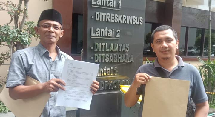 Kustiono (kiri) menunjukkan tanda terima laporan ke Polda Jatim.