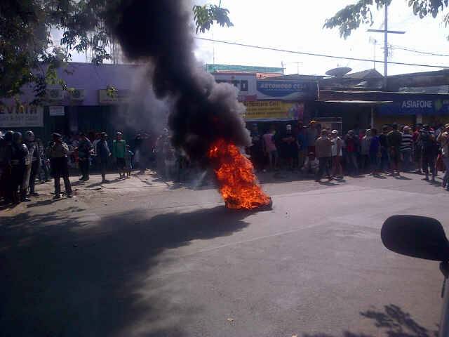 BAKAR BAN. Warga Dolly menggelar aksi pemasangan plakat dengan membakar ban di ujung Jalan Dukuh Kupang. 
