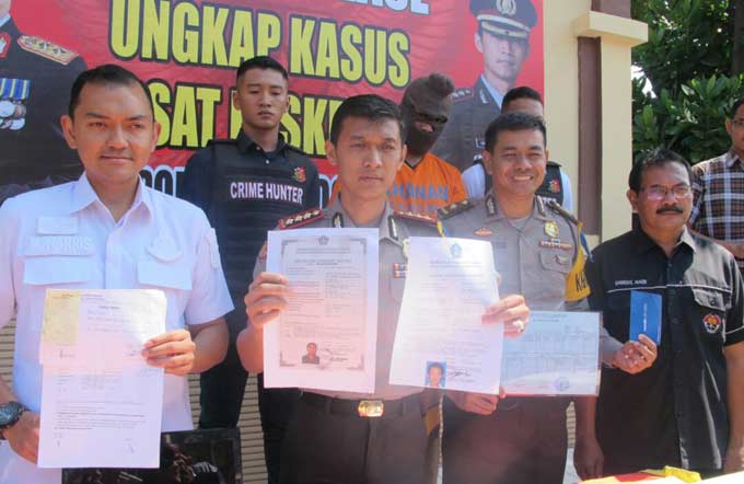 Kapolresta Sidoarjo menunjukkan barang bukti berupa dokumen yang dipalsukan tersangka.