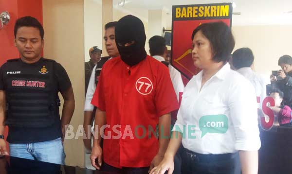 Tersangka pencabulan didampingi Kanit PPA Polrestabes Surabaya. foto:: ekoyono/ BANGSAONLINE