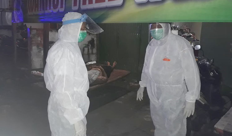 Petugas yang hendak mengevakuasi korban tampak mengenakan pakaian hazmat.