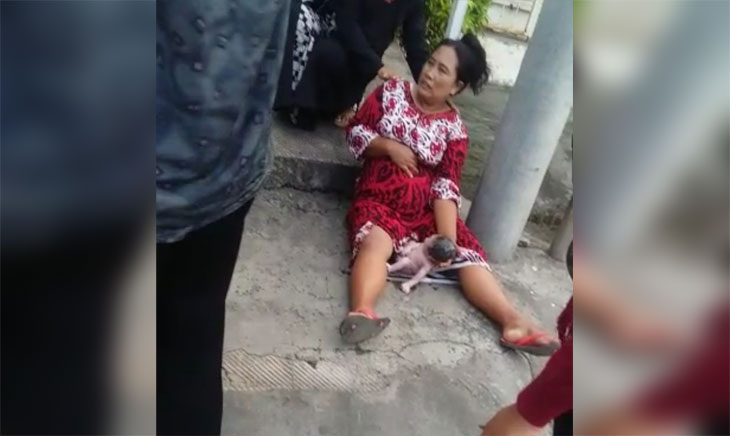 Ibu asal Desa Omben Sampang ini memegangi bayi yang brojol duluan di pinggir jalan sebelum dibawa ke RSUD Sampang.