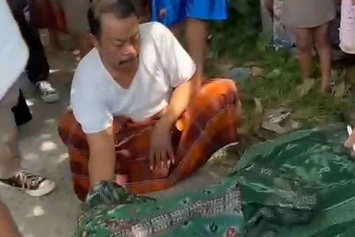 Seorang pria yang menutupi jenazah korban yang masih berusia 10 tahun jadi korban tabrak lari. Foto: Ist.