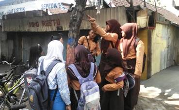 PEDULI - Sejumlah siswi tampak sedang mencabut paku di pohon yang berada di jalan Lettu Suyitno. Foto: Eky Nurhadi/BANGSAONLINE