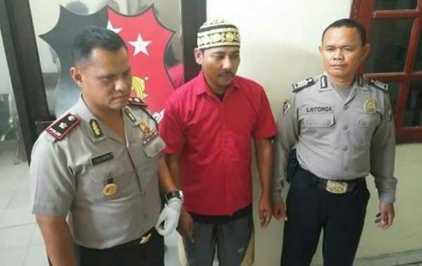 Tersangka diapit Kapolsek Sawahan dan petugas.