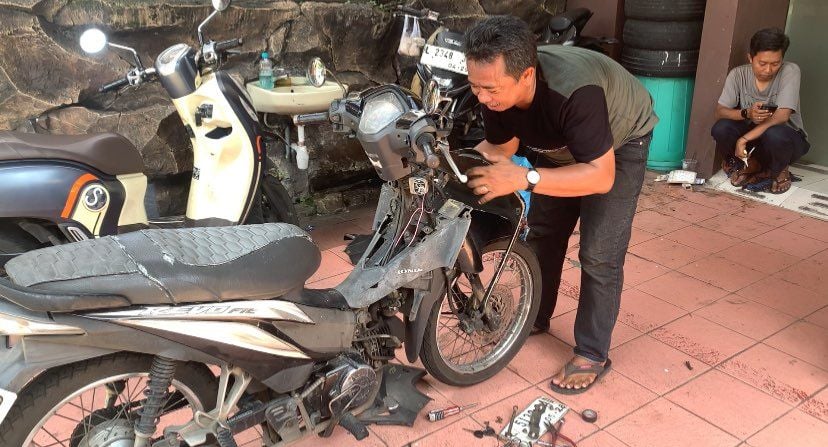 Teknisi saat memasang alarm antimaling ke motor warga di Polsek Genteng