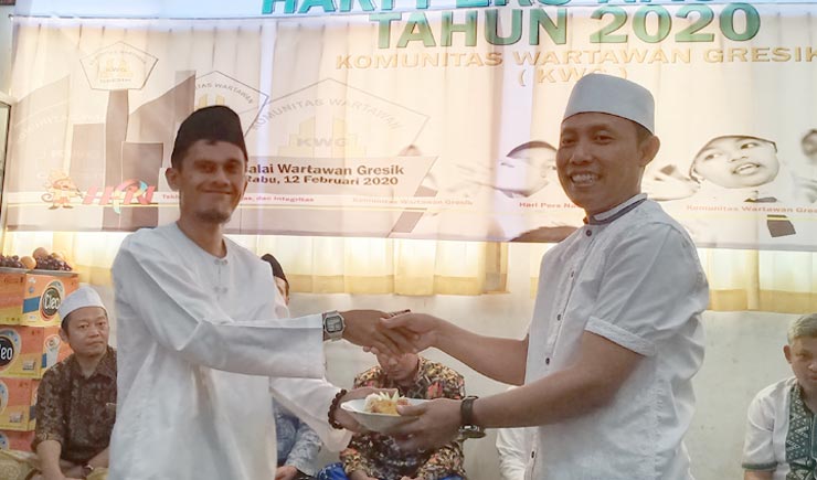 Ketua KWG M. Syuhud Almanfaluty menyerahkan potongan tumpeng kepada Ketua Panitia HPN KWG 2020, Sahlan Kurniawan. foto: ist.