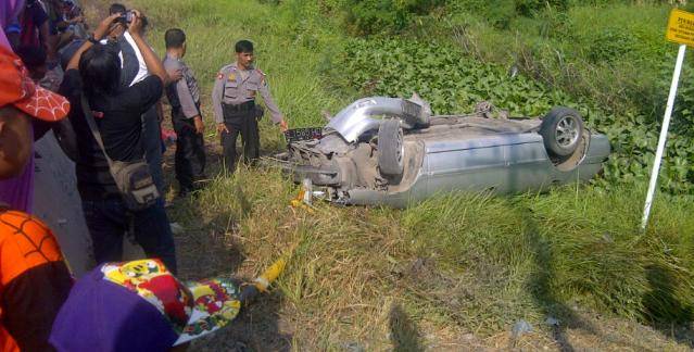 TERBALIK– Kondisi mobil sedan yang terbalik setelah diseruduk kereta api (KA), di dekat perlintasan rel KA tanpa palang pintu, di Desa Plosowahyu Kecamatan Kota Lamongan, Jum’at (25/7/2014). foto : haris sugianto/BangsaOnline

