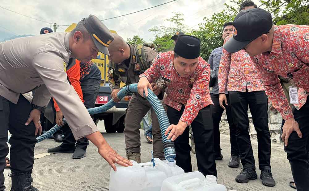 Bupati Mojokerto Muhammad Albarra saat menyalurkan air bersih ke jeriken milik warga.