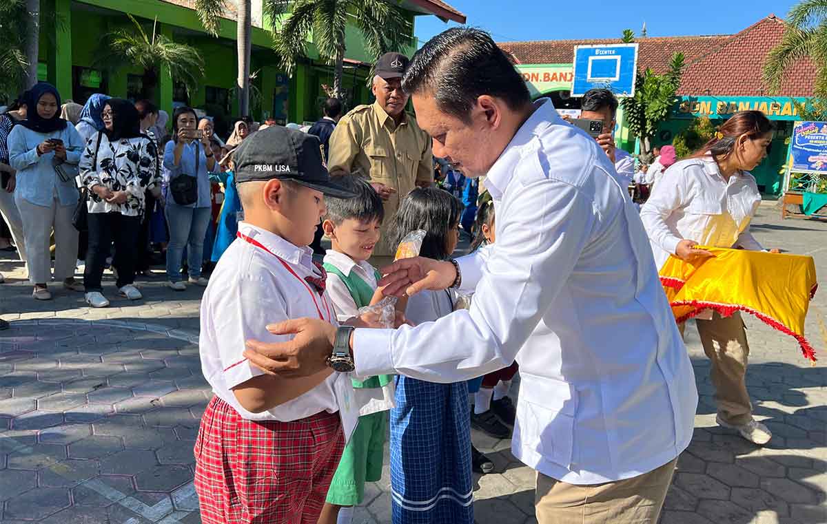 Wakil Ketua DPRD Kota Kediri, Katino, saat membagikan susu dan roti gratis kepada para pelajar. Foto: Ist