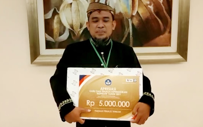 Nono Purnomo, Kepala Sekolah SMP Negeri 5 Kota Mojokerto, menunjukkan Piagam Penghargaan Tenaga Kependidikan Inspiratif dari Kemendikbud Ristek.