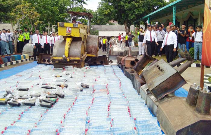 Ratusan botol miras lengkap dengan peralatan produksinya dimusnahkan di halaman Mapolres Tuban, Rabu (3/1).