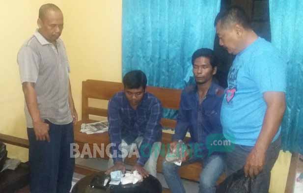 Dua pelaku (duduk) saat diamankan di Mapolsek Senori. foto: AHMAD/ BANGSAONLINE