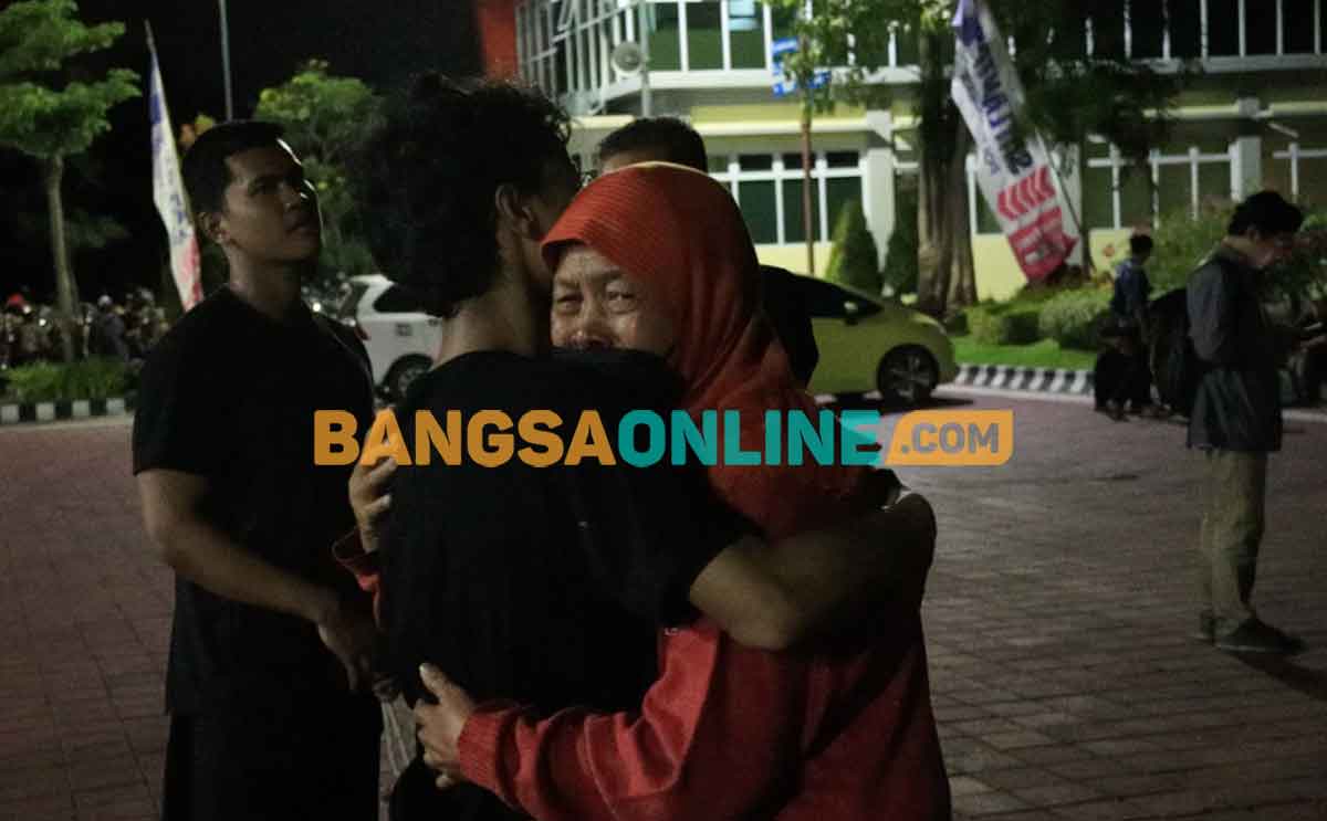Seorang ibu ketika memeluk anaknya usai dilepas Polres Gresik. Foto: SYUHUD/BANGSAONLINE