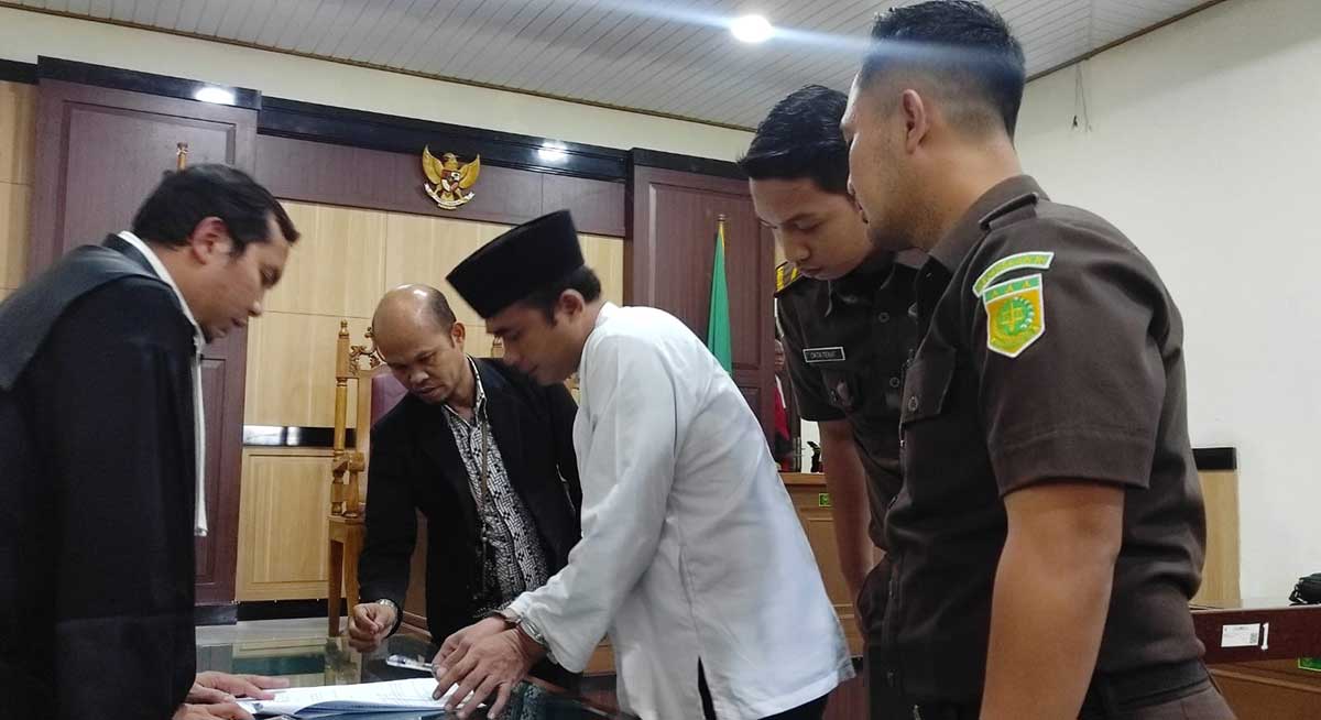 Midhol (berkopiah) saat menjalani sidang putusan. Foto: Ist