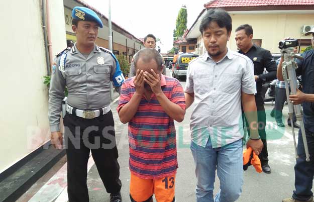 Mujiono saat dibawa ke Polres Blitar Kota. foto: AKINA/ BANGSAONLINE