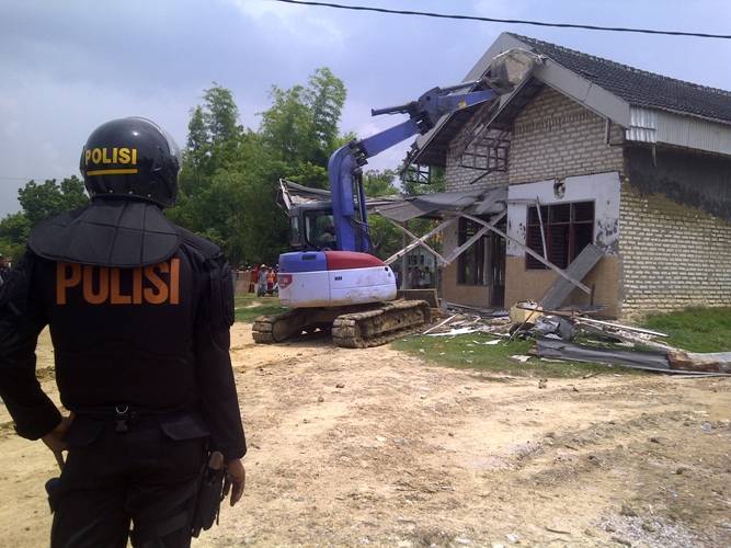 Salah satu rumah keluarga tergugat dihancurkan dengan alat berat begho saat eksekusi lahan di Desa Pagagan, Pademawu, Pamekasan, Senin (10/3). Foto: Rizal