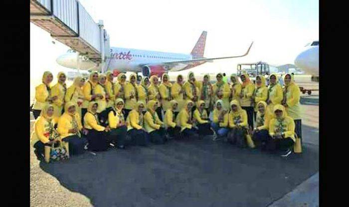 Tim Penggerak PKK Kabupaten Jombang berpose dengan latar pesawat terbang. Keberangkatan mereka ke Jakarta disorot lantaran menggunakan dana desa.