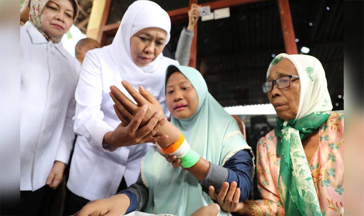 Gubernur Khofifah Bantu Pasangkan Jari Pada Widji Sambil Distribusikan PKH Plus