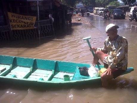 Husein, kakek yang memanfaatkan bencana banjir sebagai lahan untuk mengeruk rupiah. foto: detik.com