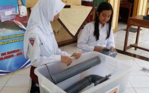 Dua siswi SDN 1 Kranggan saat sedang memperagakan penemuan mesin pencuci telur hemat biaya dan waktu. foto istimewa