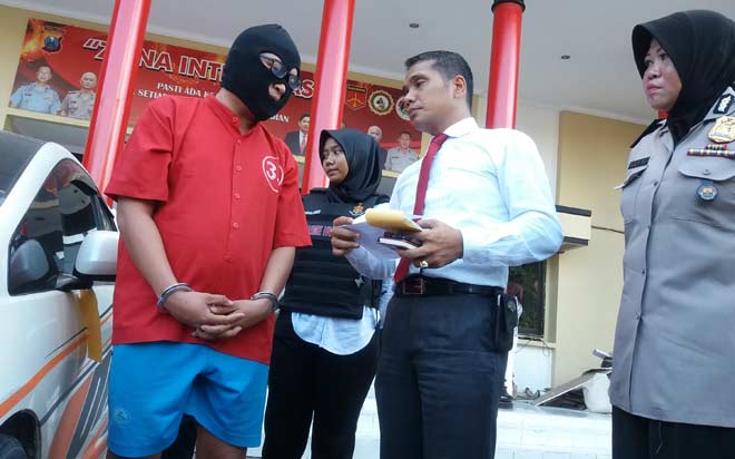 Pengacara yang menggelapkan mobil didampingi Kasatreskrim dan KaHumas Polrestabes Surabaya.
