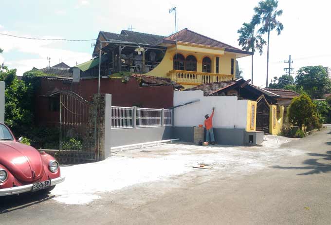 Salah seorang pekerja SBR sedang mengecat tembok sekaligus kawasan akses masuk yang ditolak warga RT 04 Mojolangu. foto: IWAN/ BANGSAONLINE