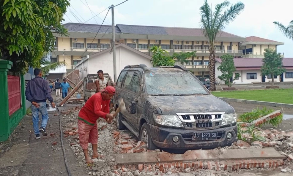 Sebuah mobil tertimpa bangunan yang ambruk akibat diterjang angin kencang.