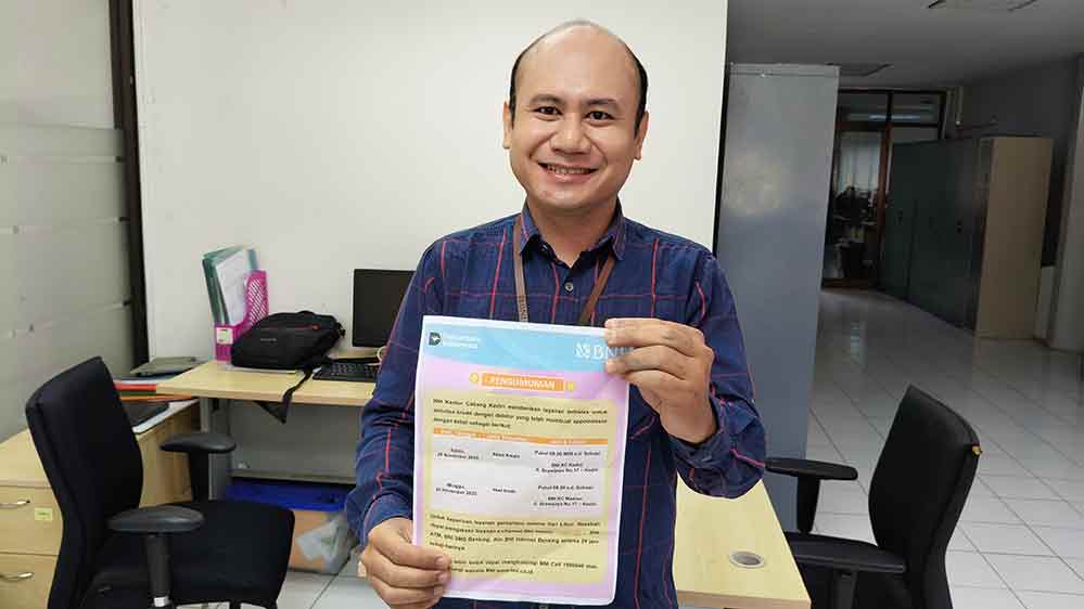 Unit Kredit Consumer BNI KC Kediri, Andi Setiyono, saat menunjukkan pengumuman layanan terbatas. Foto: Muji Harjita/Bangsaonline.