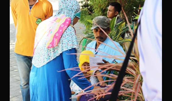 Sang Istri ngantre urus e-KTP, sementara suami jaga balita. Pemandangan ini terlihat di Kecamatan Bulak. Foto diambil Selasa (6/09). foto: luckman hakim/ BANGSAONLINE