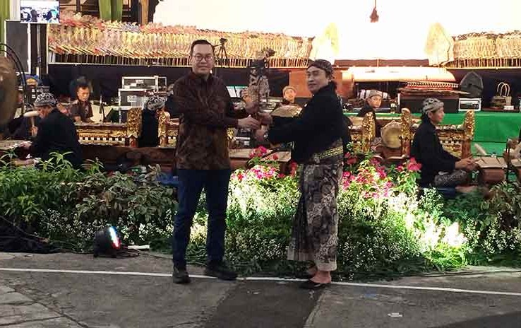 Direktur Keuangan dan Umum Petrokimia Gresik, Adityo Wibowo (kiri) menyerahkan wayang kepada dalang Ki Anom Dwijokangko pertanda dimulai gelaran wayang kulit. Foto: Syuhud/Bangsaonline.