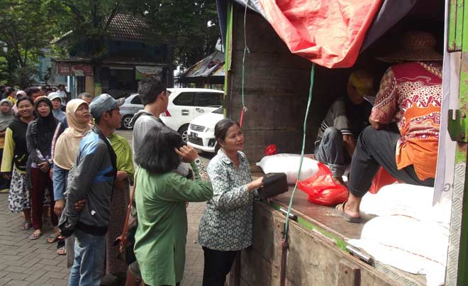 MENGULAR: Sejumlah warga antre membeli sembako murah operasi pasar di Pasar Larangan, Candi, Sidoarjo, Rabu (1/6/2016).  foto: musta