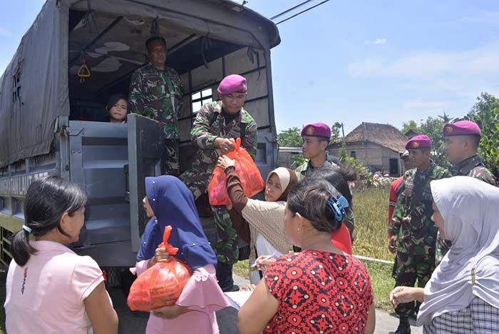 Petugas Satgas Bencana Banjir Pangkalan Utama TNI AL V (Lantamal V) Koarmada ll saat membagikan bahan kontak.